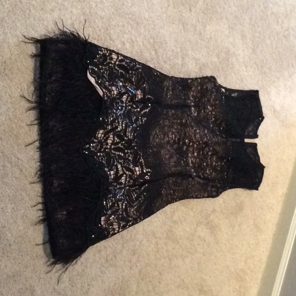 sleeveless black dress with black feathers.